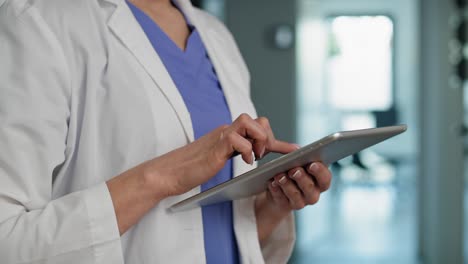 caucasian female doctor using digital tablet in medical clinic.