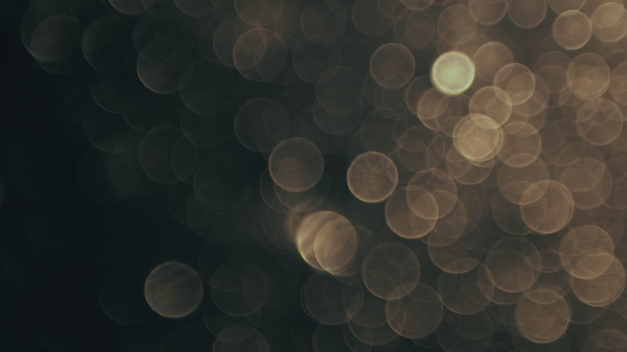 Luci bokeh dorate astratte scintillanti su sfondo scuro