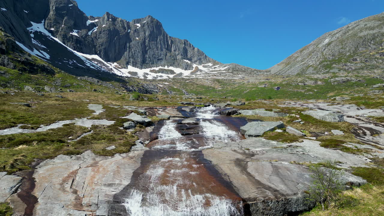 una foto fantástica de la cascada de molneva y hermosas montañas nevadas en el fondo