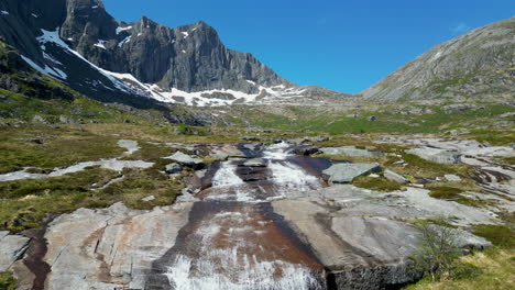 fantastic shot of the molneva waterfall and beautiful snowy mountains in the background