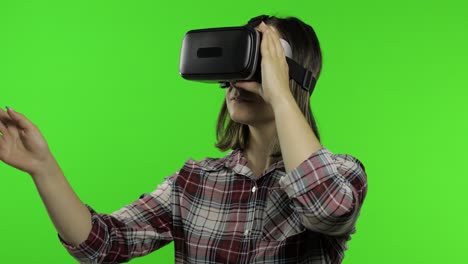 girl using vr app helmet to play simulation game. slide gestures. watching virtual reality 3d video