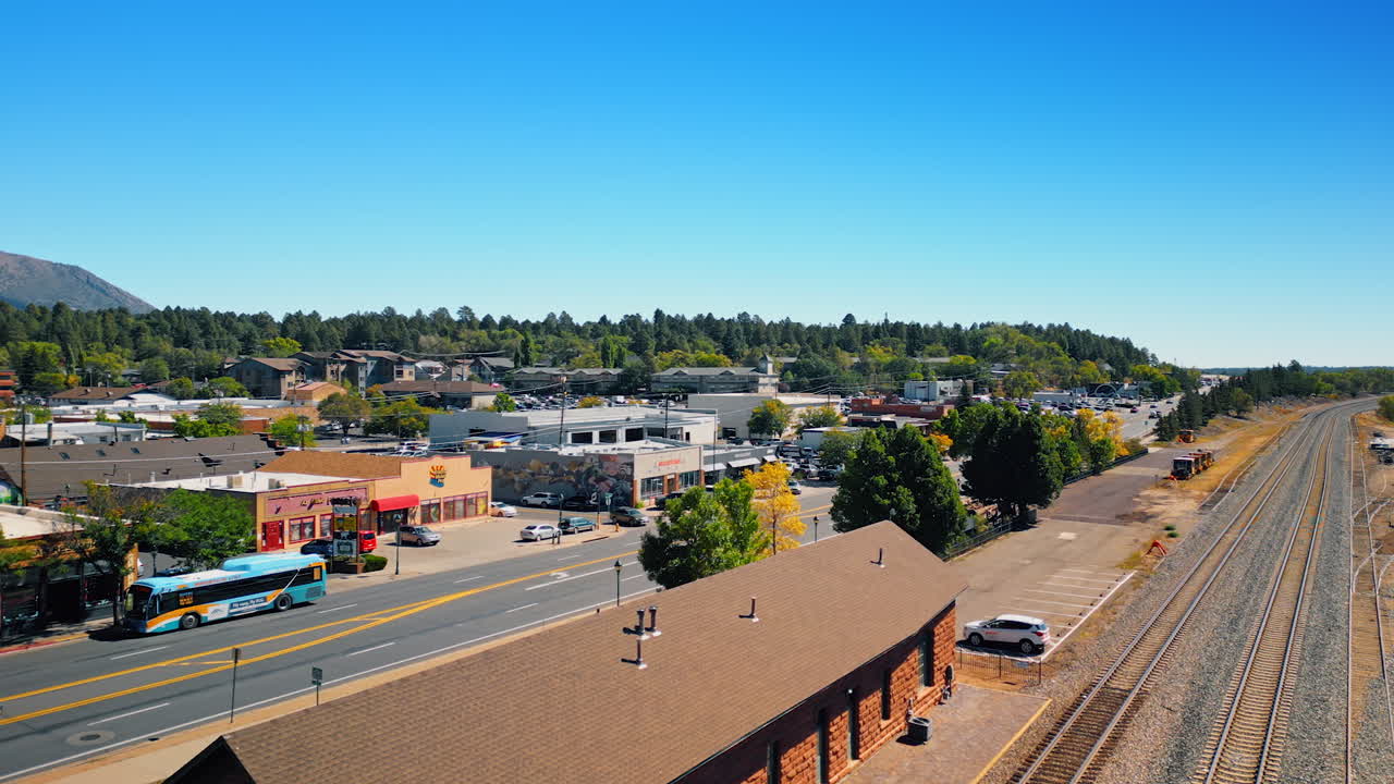 Flagstaff, USA, 24 August 2025: Railways and station of Flagstaff, Arizona, USA. Aerial view. Beautiful green wood at backdrop. Aerial view