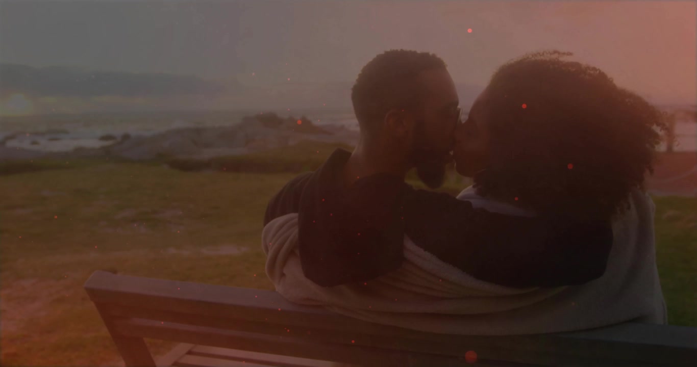 Casal se Abraçando e Beijando em um Banco ao Pôr do Sol