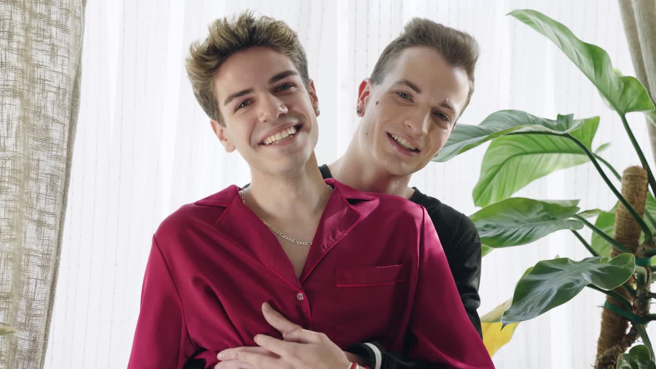 Happy Young Gay Couple Hugging and Smiling at Home