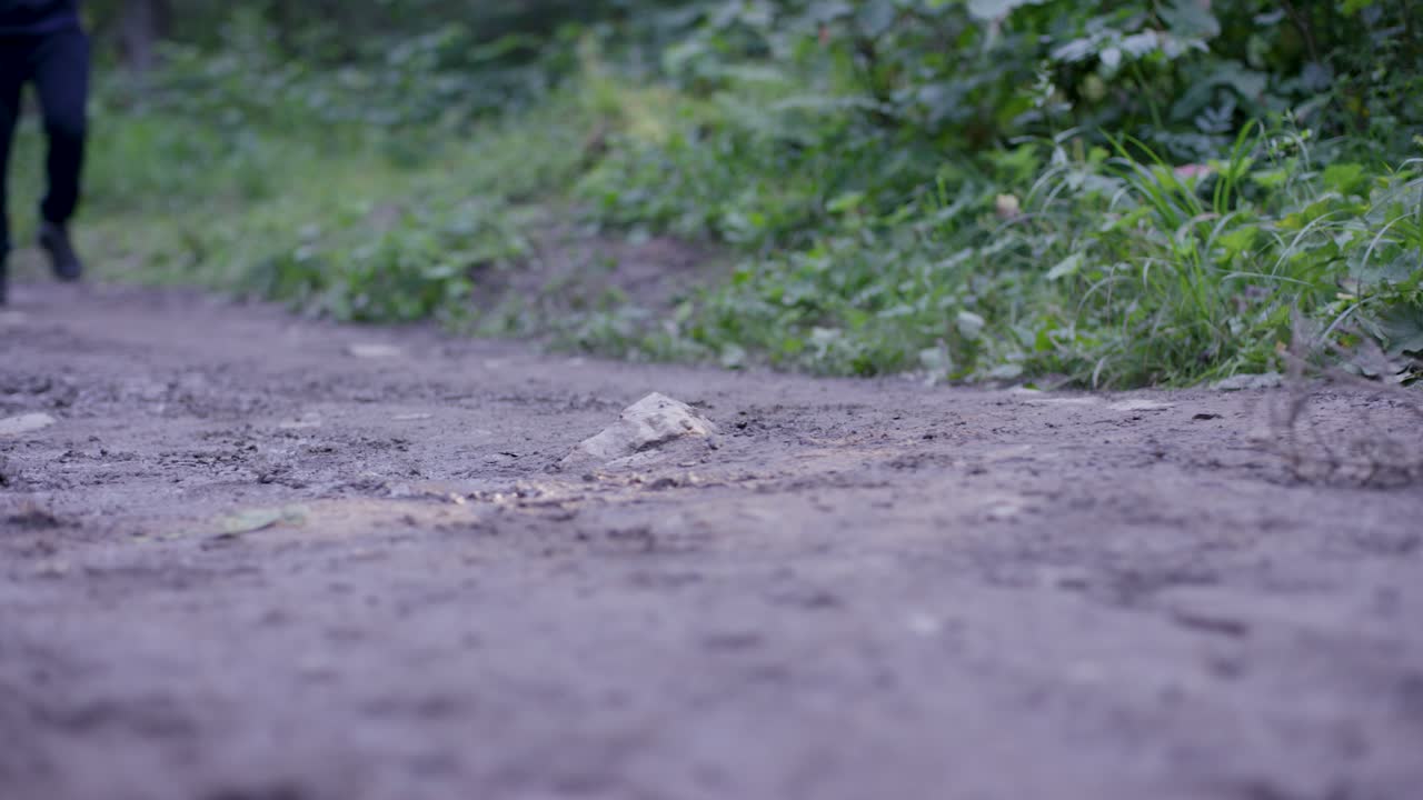 persona caminando por un sendero de bosque fangoso