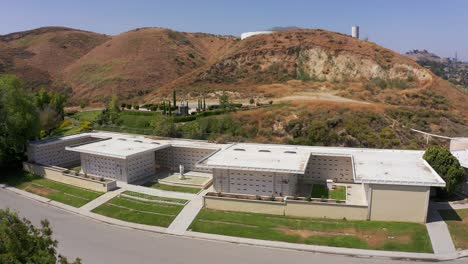 panning aerial shot of a large stone mausoleum at a mortuary in california