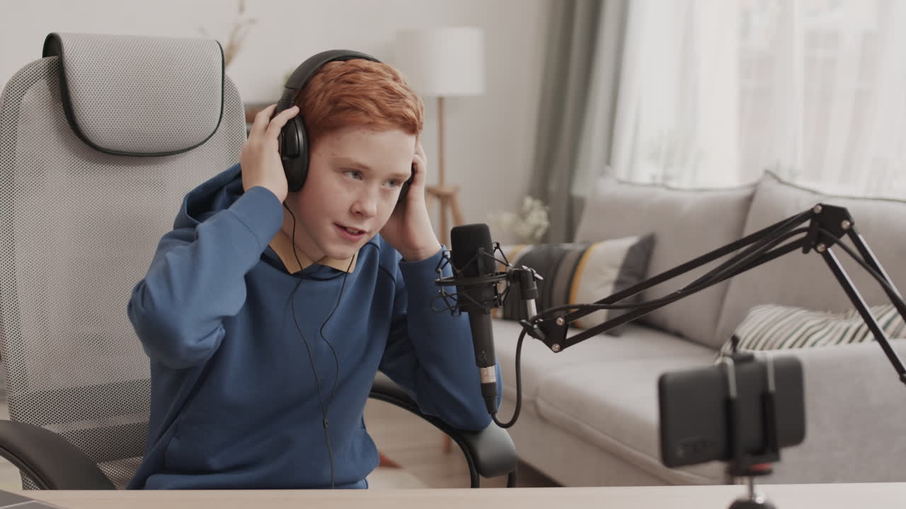 Teenager recording podcast with headphones and microphone