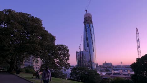 Woman-Walking-in-park-under-Skyscraper