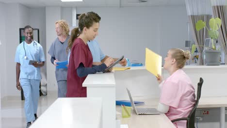 diversos médicos hablando con recepcionista médica sentados en la recepción en el hospital, cámara lenta
