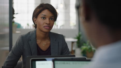 beautiful-african-american-business-woman-using-digital-tablet-computer-colleagues-discussing-project-management-information-sharing-ideas-planning-strategy-professional-office-teamwork