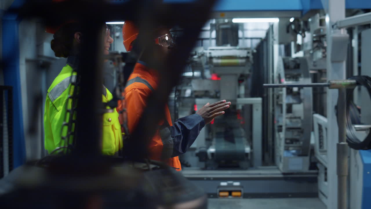 Supervisors talking modern factory wearing safety uniform together. Team work