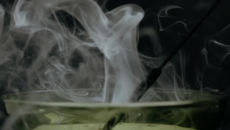 a smoky relaxing scene with a bowl of essence burning on a stick , making soft calm waves of smoke