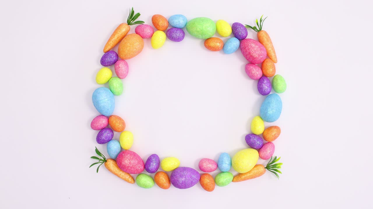 Happy Easter write in frame made of vibrant eggs on white background. Stop motion flat lay