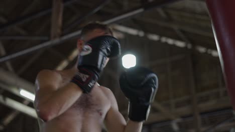shirtless boxer training in a gym