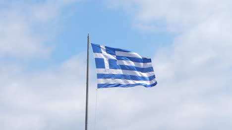 flag of greece in de wind with clouds and blue sky background slomo