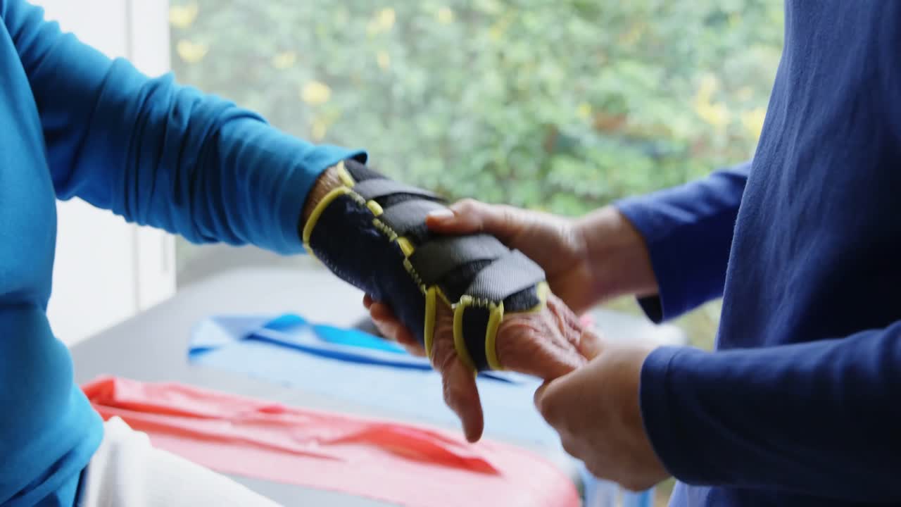 fisioterapeuta examinando la mano de una mujer mayor 4k