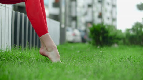 woman stretching barefoot in grass