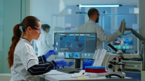 médico de química analizando una muestra de sangre y escribiendo en la computadora