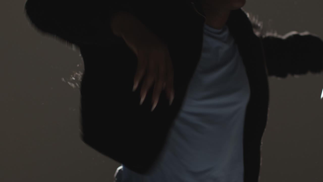 близко освещенная голова и плечи студийный портрет молодой женщины, танцующей на улице в прожекторе 1