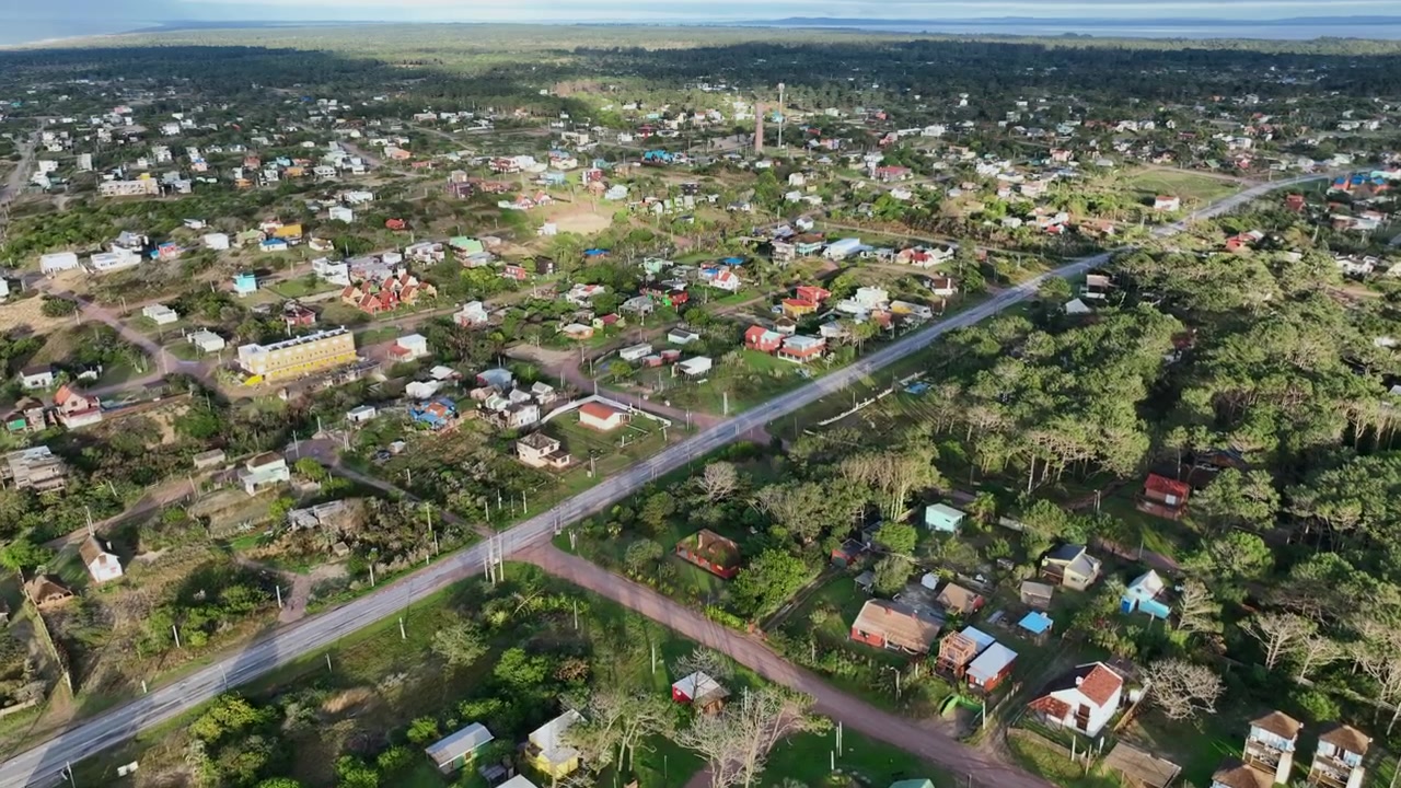 Quartiere residenziale di Punta del Diablo, ripresa aerea in avanti sopra case e vegetazione a Rocha, Uruguay