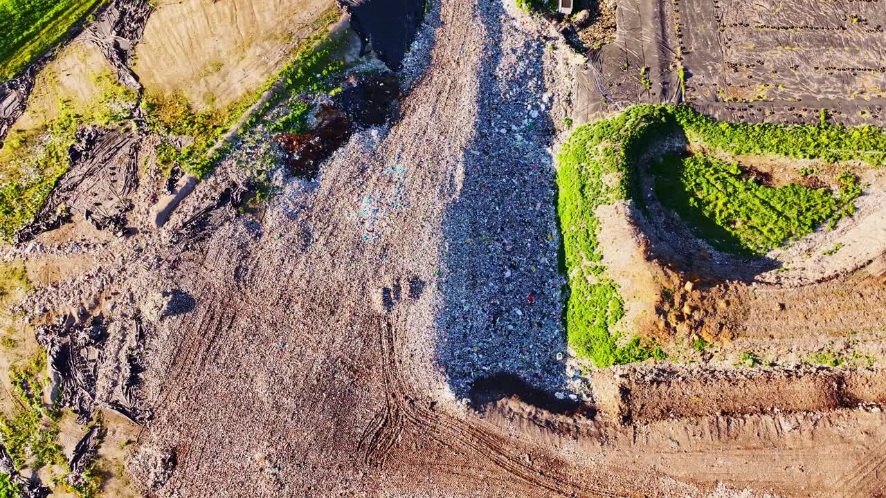 Rotating aerial shot over waste site with green slopes in Jelgava countryside