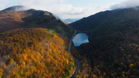 Aerial-view-from-a-lake-in-Upstate-New-York-surrounded-with-fall-foliage