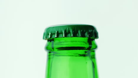 the neck of a glass bottle with a drink is covered with a green lid hd video