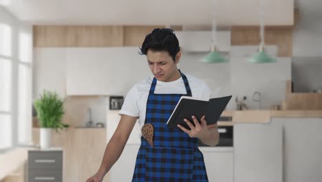 confused indian cook making food from recipe book