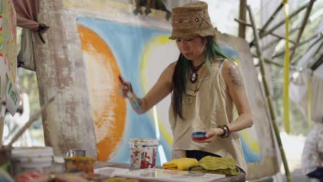 woman artist painting large abstract canvas outdoors