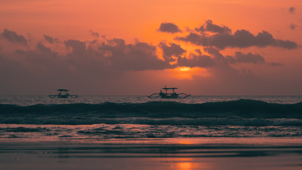 인도네시아 발리에서 해가 지는 동안 짐바란 해변에서 떠다니는 전통적인 보트