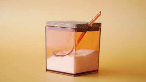 closeup of a brown sugar container with a wooden lid and a spoon