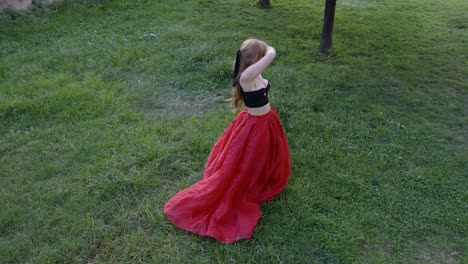 High-shot-of-a-woman-dancing-on-grass-field