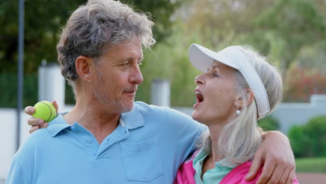 Pareja-Mayor-Hablando-En-La-Cancha-De-Tenis-4k