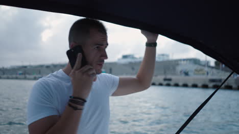 man talking on a phone from a boat