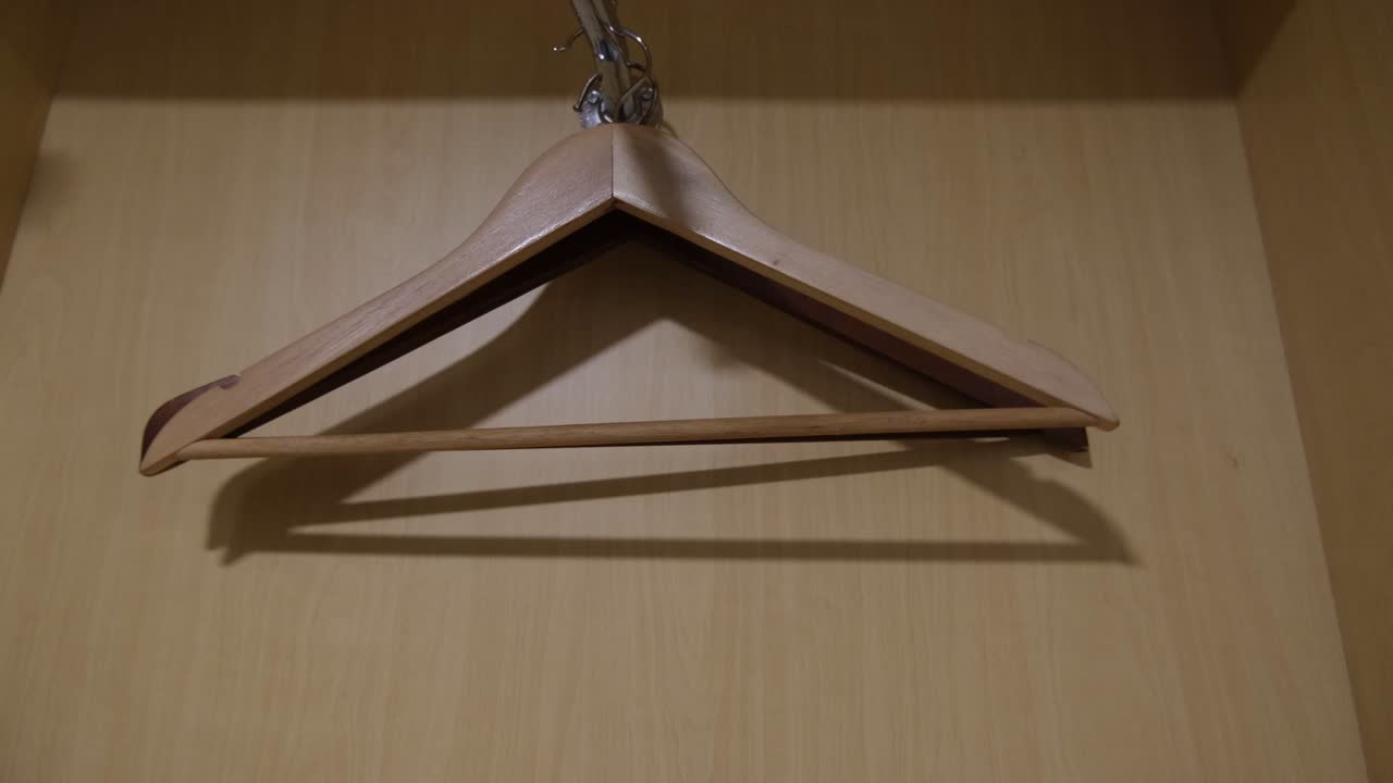 algunas perchas de ropa vacías dentro de un armario de madera, armario