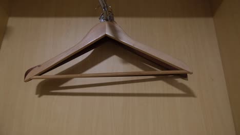 some empty clothes hangers inside wooden wardrobe, closet