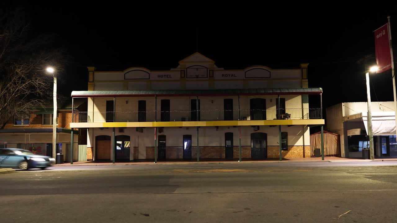 트럭 과 자동차 가 오래된, 조명 된 건물 을 지나간다