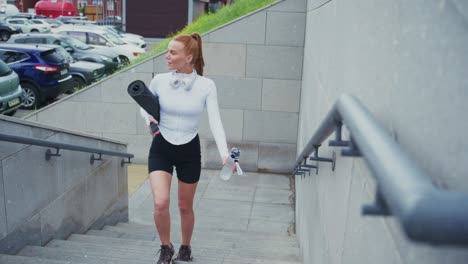 woman with yoga mat on stairs