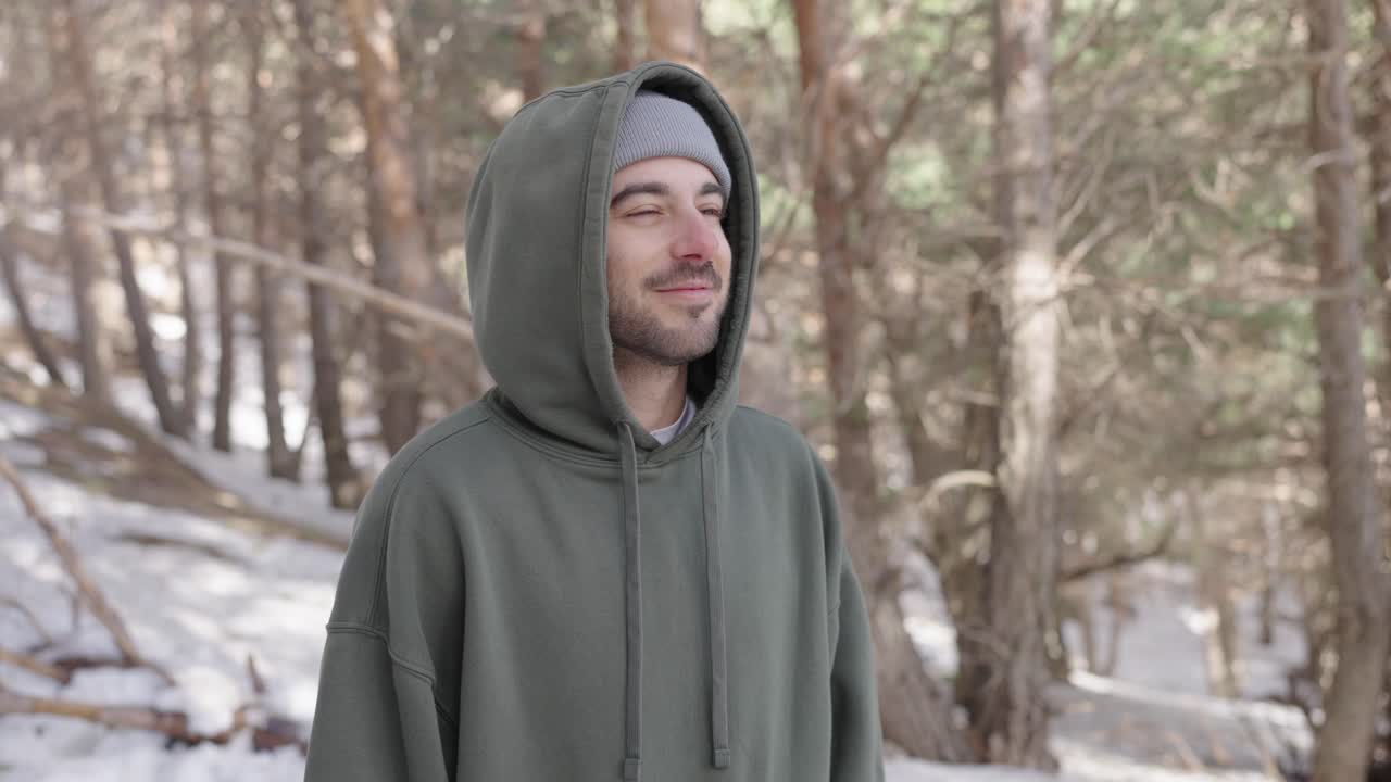 Man in Hoodie in Snowy Forest