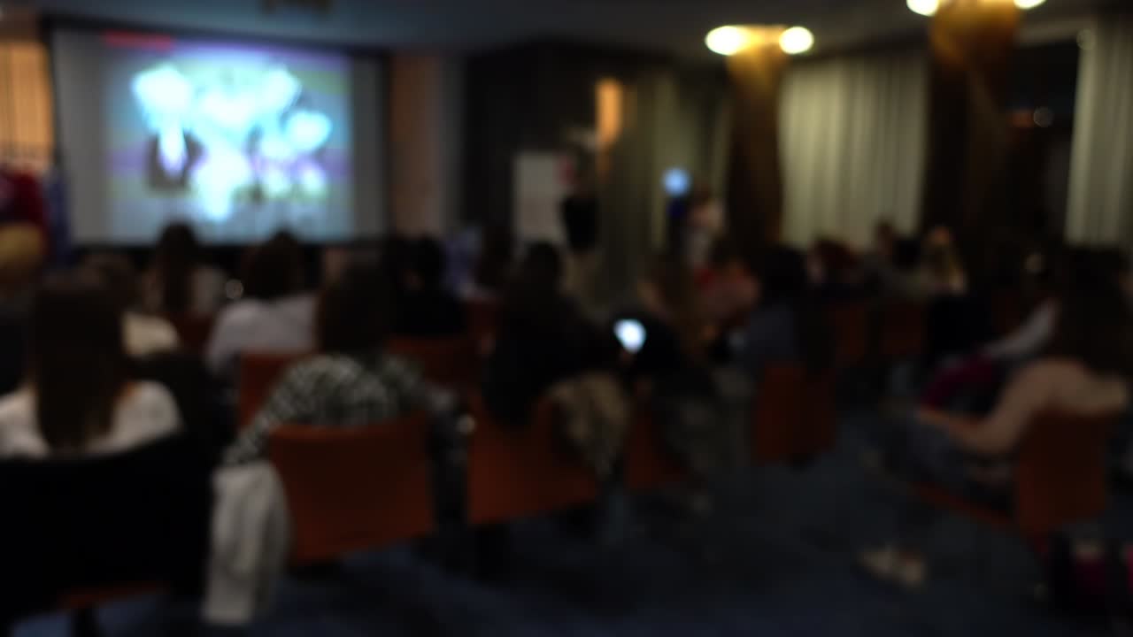 Lezione in aula con l'ausilio di uno schermo informativo. Sfocato.