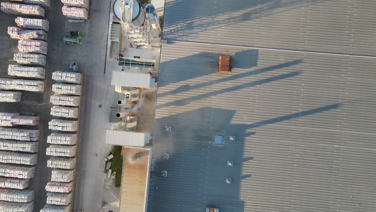 vuelo de drones sobre la fábrica de azulejos y el edificio del almacén con chimenea y existencias de productos