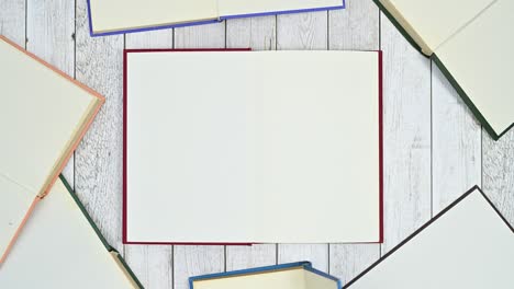 una pila de libros de tapa dura aparecen y se abren en tema de madera.
