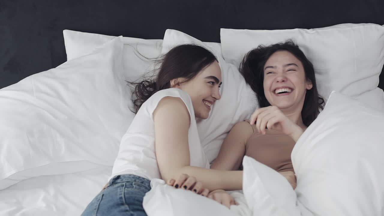 Two Women Laughing in Bed