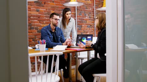 Group-of-executives-discussing-over-laptop-in-the-conference-room