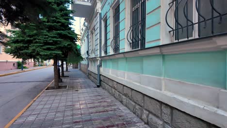 a sidewalk and street in crimea, russia, are empty under a clear blue sky