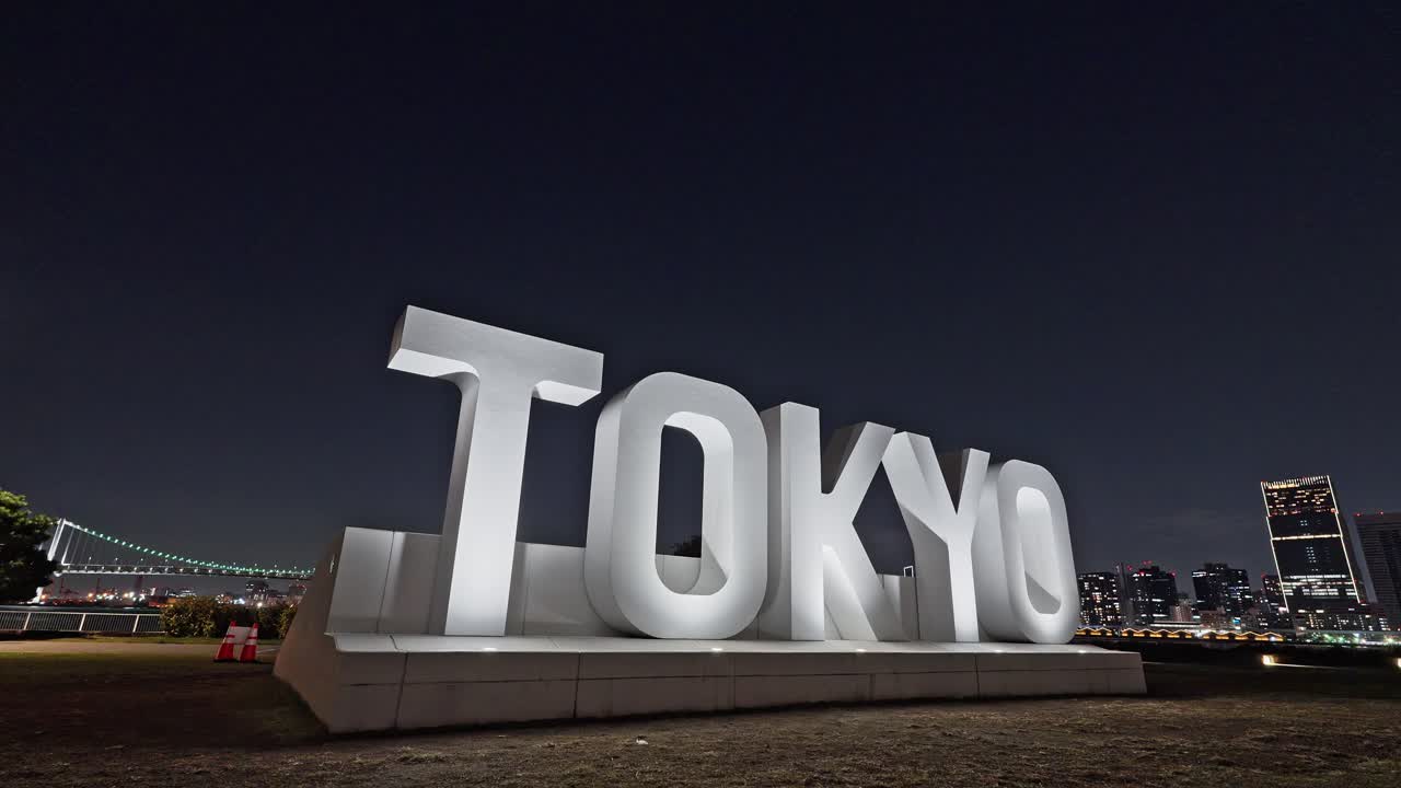 Strikingly symmetrical night view of Tokyo Bay skyline, Rainbow Bridge, and a formal array of white fountains
