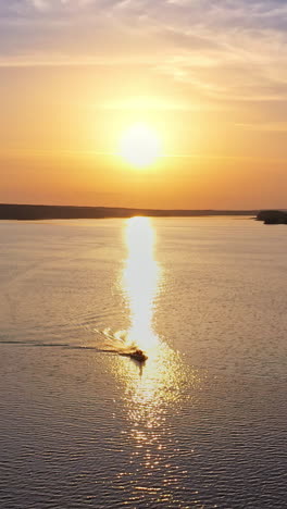 beautiful sunset is reflecting in the river. sunset lake landscape. colorful sky. nature and water. plant with smoking pipes on the riverbank. vertical video