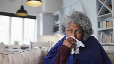 Kranke-ältere-Afroamerikanische-Frau,-Die-Mit-Einer-Decke-Bedeckt-Ist-Und-Zu-Hause-Auf-Der-Couch-Sitzt