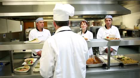 jefe de cocina comprobando sus equipos platos en la estación de orden