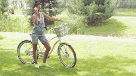 young cyclist talking phone in park